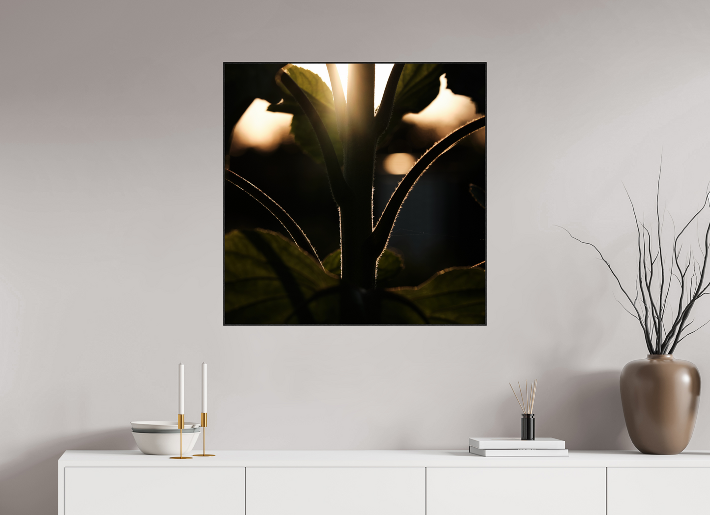 Lifestyle foto van een kunstprint van zonnebloem steel bij zonsondergang ingelijst in een houten galerielijst van 80x80cm.