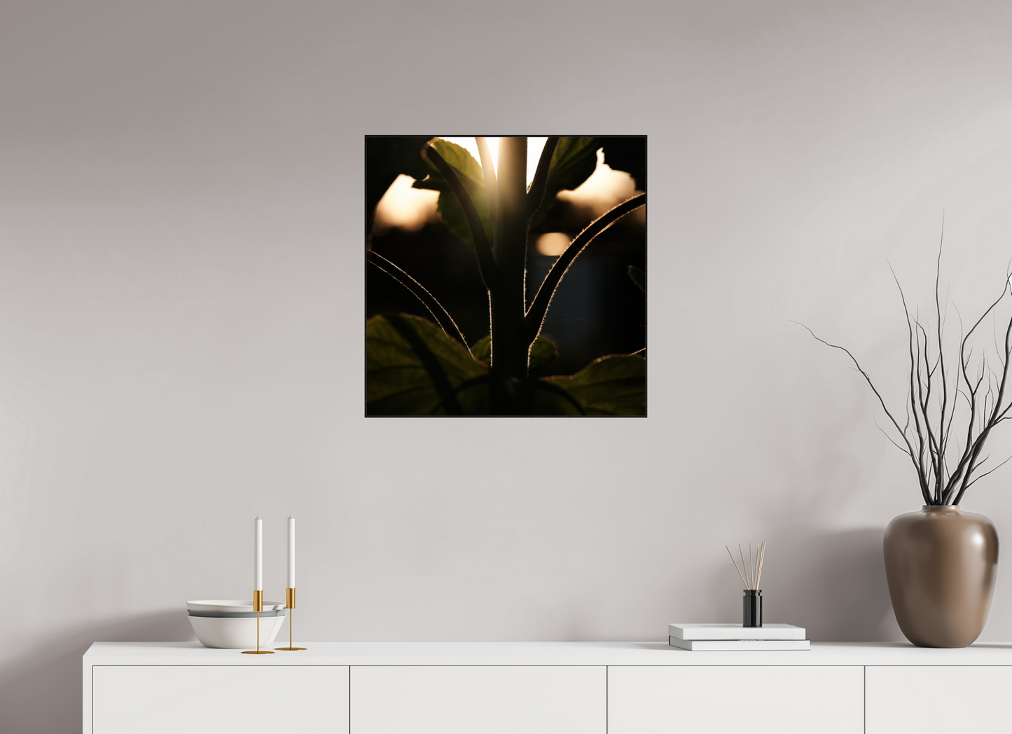 Lifestyle foto van een kunstprint van zonnebloem steel bij zonsondergang ingelijst in een houten galerielijst van 60x60cm.