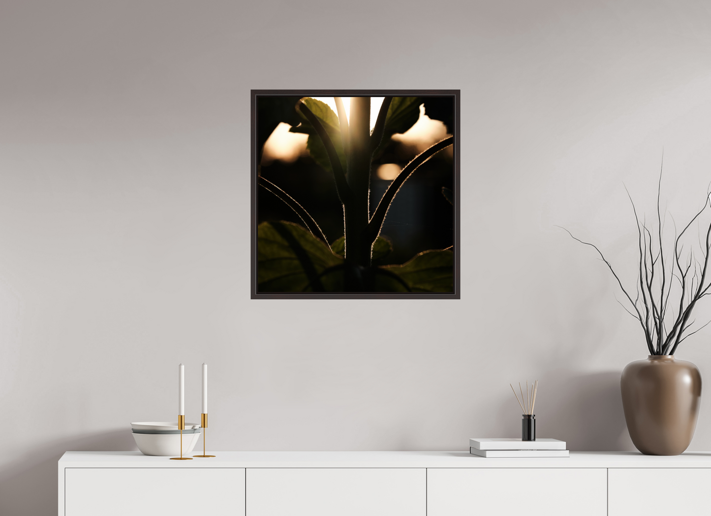 Lifestyle foto van een kunstprint van zonnebloem steel bij zonsondergang ingelijst in een houten galerielijst met schaduwvoeg van 60x60cm.