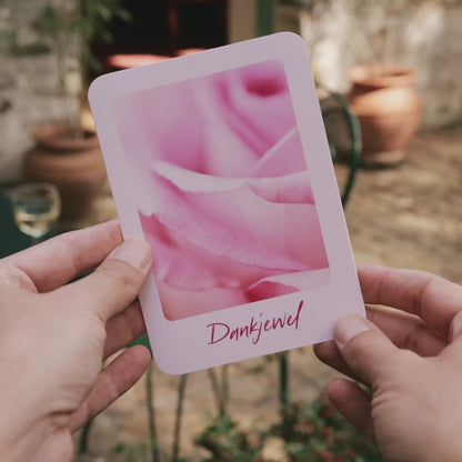 Productvideo van een bedankkaartje met een foto van een roze roos. Op de achtergrond een mooie Franse setting.